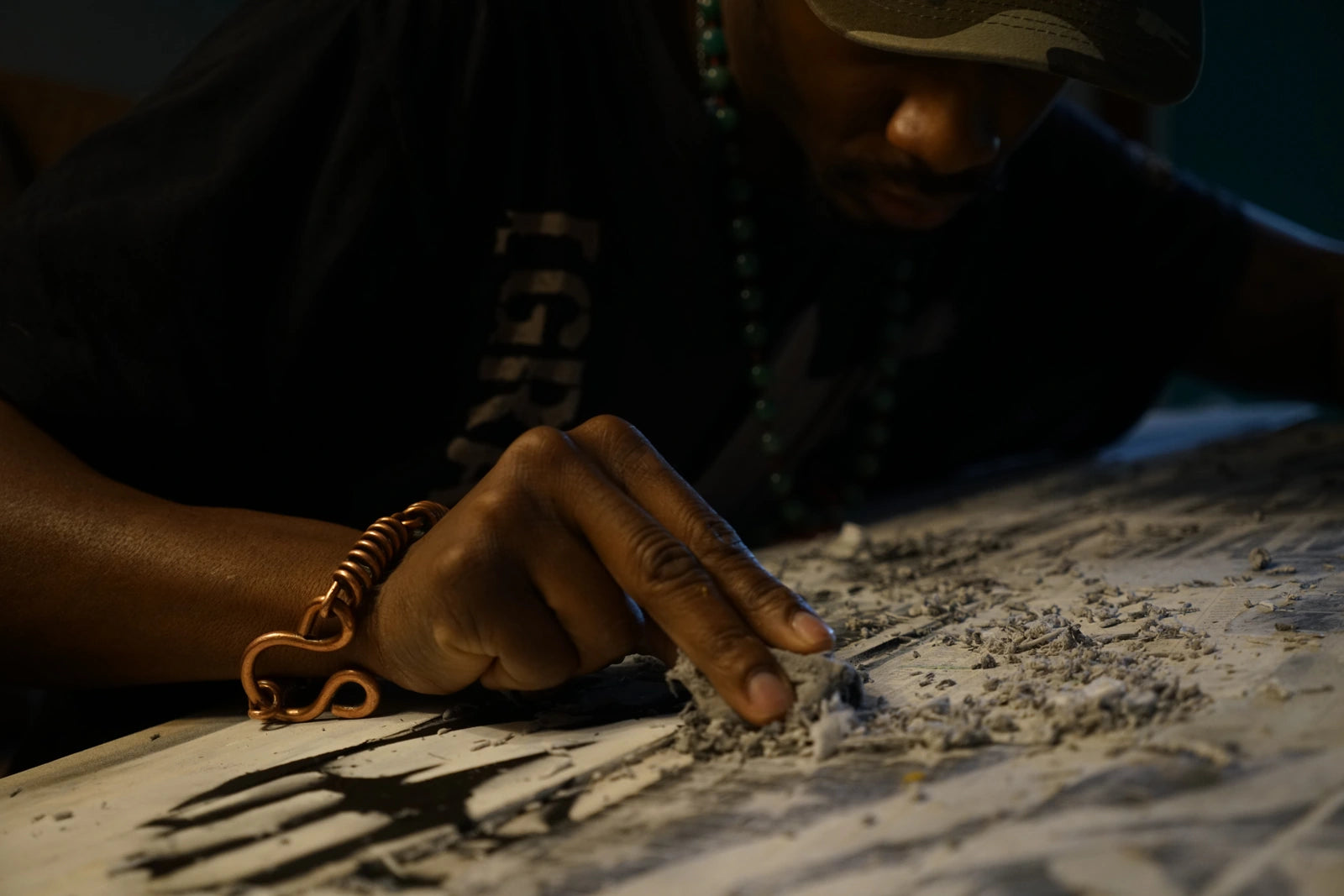 Artist working on a piece, with his hand in the foreground